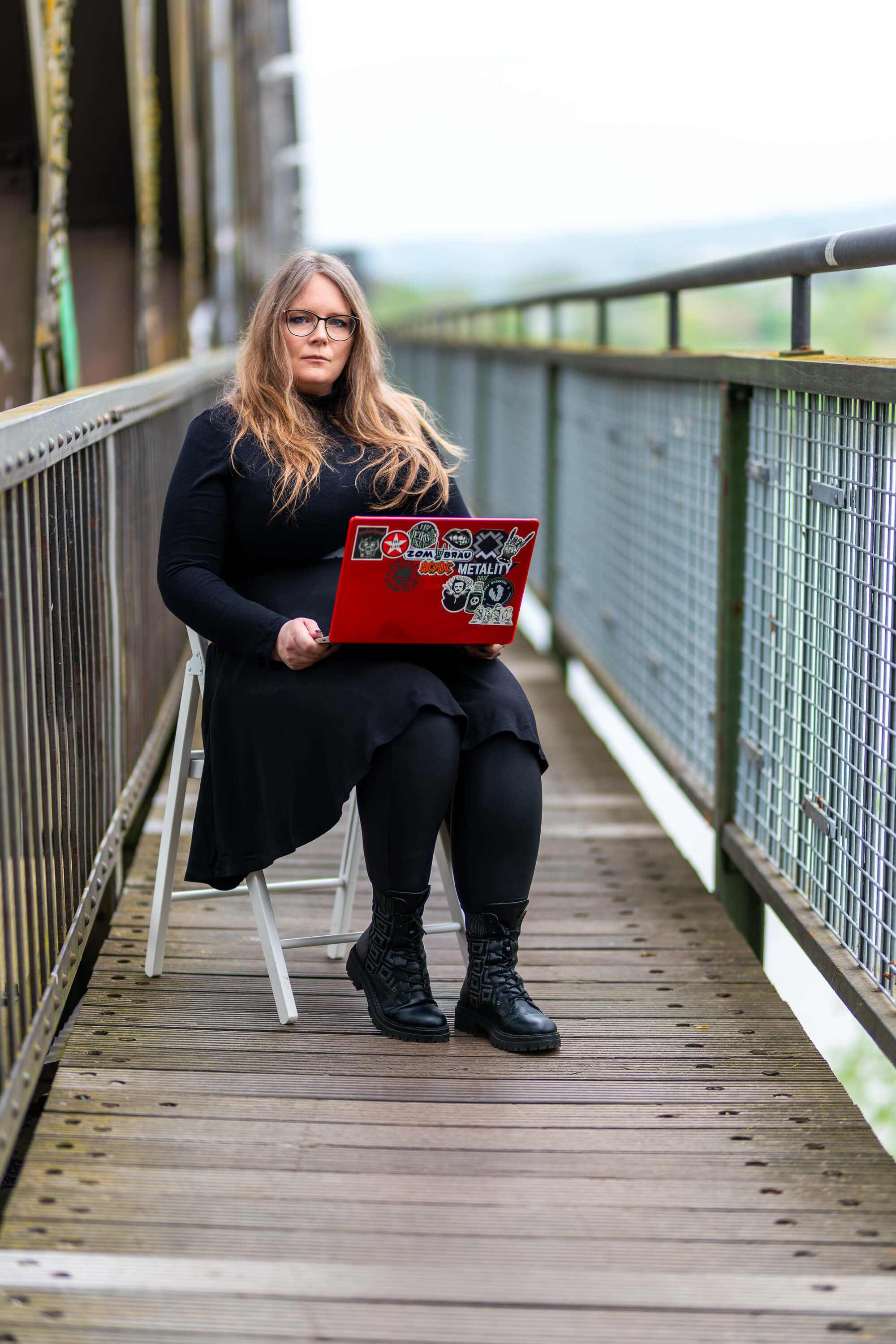 Nadine Huss sitzt mit Laptop auf ener Brücke und stellt sich vor